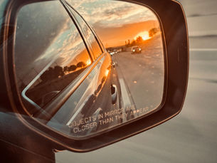 A car's rearview mirror symbolizes leaving something behind 